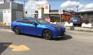 Niebieska Toyota Mirai, samochód wodorowy, parkuje obok stacji paliw. Sprawdzamy, jaka jest toyota mirai cena.