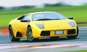 Żółty Lamborghini Murcielago pędzi po torze wyścigowym, zostawiając za sobą rozmyte zielone krajobrazy.