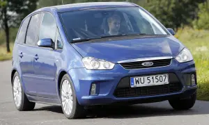 Niebieski Ford C-Max 1.6 benzyna z mężczyzną za kierownicą jedzie po drodze wśród zieleni.