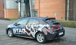 Samochód hybrydowy z grafiką STAG, informującą o paliwie: cng i hybryda. Nowoczesny design podkreśla ekologiczny napęd.