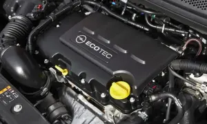 Silnik Ecotec w Oplu Astra J 1.4 Turbo. Widoczne elementy układu dolotowego i osłona silnika z logo.