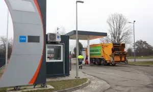 Stacja paliw z oznaczeniem CNG, gdzie można tankować gaz. Obok żółta śmieciarka z napisem "System Eko".