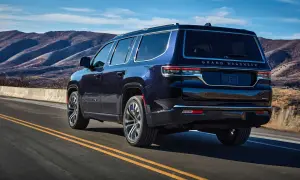 Granatowy Grand Wagoneer pędzi po górskiej drodze, zostawiając za sobą malownicze krajobrazy.