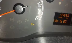 Kontrolki w Oplu: ABS, hamulec, poduszka, drzwi, bagażnik. Na wyświetlaczu przebieg 134696 km i czas 15:30.