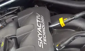 Silnik SKYACTIV TECHNOLOGY, jeden z najlepszych silników benzynowych, z widocznymi przewodami i złączkami.