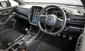 Wnętrze Subaru STI z dużym ekranem dotykowym, cyfrowymi zegarami i sportową kierownicą. Gotowy na jazdę!
