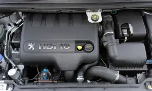 Silnik Peugeot 307 2.0 HDI 16V. Widoczny czarny plastikowy kolektor, przewody i akumulator.