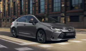 Szara Toyota Corolla GR Sport jedzie ulicą miasta. W środku siedzi para.