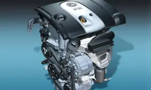 Silnik samochodowy 1.6 MPI z widocznymi paskami, alternatorem i osłoną z logo VW.
