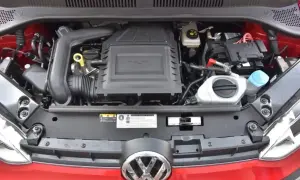Silnik 1.0 TSI w czerwonym samochodzie Volkswagen. Widoczny akumulator, płyny i elementy układu dolotowego.