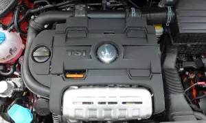 Silnik TSI w Volkswagen Polo 6R. Widoczny czarny plastikowy dekiel z logo VW i napisem TSI, a pod nim metalowa osłona.