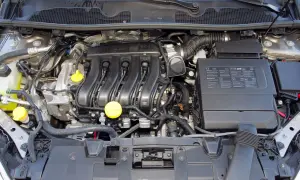 Silnik samochodu Renault Megane 3, z widocznymi przewodami, cewkami zapłonowymi i żółtymi korkami.