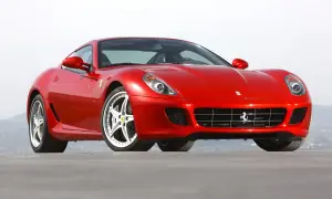 Czerwone Ferrari 599, błyszczące w słońcu, z charakterystycznym grillem i felgami. Marzenie każdego miłośnika motoryzacji.