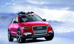 Czerwony Audi Q1 z nartami na dachu gotowy na zimową przygodę w górach.