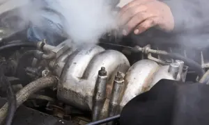 Para wylatuje z silnika. Czy można wlać płyn chłodniczy do ciepłego silnika? Mechanik sprawdza problem.