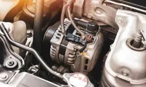 Zbliżenie na alternator samochodowy z widocznymi przewodami i złączami.