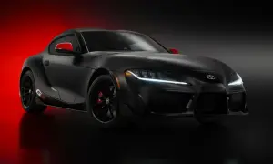 Czarna Toyota Supra GR z czerwonymi akcentami na lusterkach i zaciskach hamulcowych, prezentująca sportowy design.