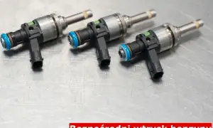 Trzy wtryskiwacze paliwa do silnika z bezpośrednim wtryskiem benzyny (GDI) na metalowej powierzchni.
