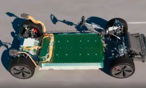 Podwozie samochodu elektrycznego z zieloną baterią i żółtymi kablami. Widoczne elementy układu napędowego i zawieszenia. Widać potencjalne natężenie pola elektrycznego wokół komponentów.