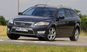 Ciemnoszary Ford Mondeo MK4 2.0 TDCI na drodze, z widocznym polem zboża w tle.