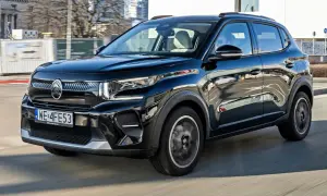Czarny Citroën C3 Aircross pędzi ulicami miasta, odbijając w swojej lśniącej karoserii miejski krajobraz.