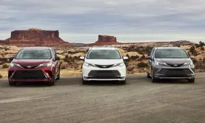 Trzy samochody Toyota Sienna w kolorach: wiśniowym, białym i grafitowym, stoją na tle pustynnego krajobrazu z formacjami skalnymi.