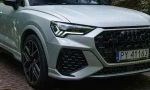 Srebrne Audi RS Q3 z czarnymi felgami i agresywnym grillem, gotowe do jazdy po warszawskich ulicach.