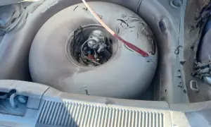 W bagażniku samochodu widać okrągłą butlę LPG, która wygląda na starą i zakurzoną. Czerwony przedmiot leży na jej powierzchni. Czas na wymianę, bo kończy się ważność butli LPG.