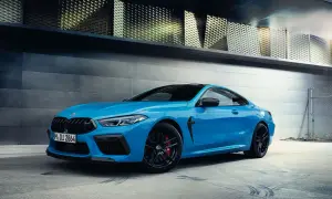 Niebieskie BMW M8 Coupe na tle nowoczesnej architektury.