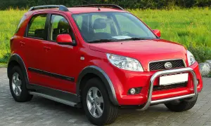 Czerwony Daihatsu Terios z metalowym orurowaniem z przodu, gotowy na przygodę.
