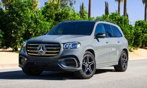 Szary Mercedes-Benz GLS na tle zieleni. Elegancki SUV z charakterystycznym grillem i felgami.