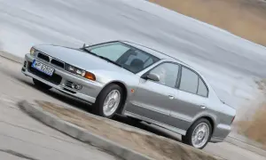 Srebrny Mitsubishi Galant z gracją pokonuje zakręt.