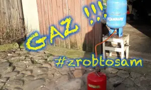 Gaz! Jak zakręcić zawór butli LPG? Czerwona butla z gazem i niebieska butla na stołku, połączone wężem. #zróbtosam