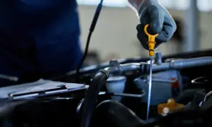 Mechanik sprawdza poziom oleju w silniku. Odma w samochodzie jest kluczowa dla jego prawidłowego działania.