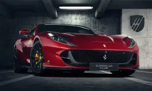 Czerwone Ferrari 812 GTS z żółtymi zaciskami hamulcowymi stoi w garażu.