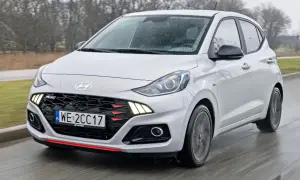 Biały Hyundai i10 N Line w ruchu, z widocznym grillem i światłami LED. Sprawdź aktualną hyundai i10 cena.