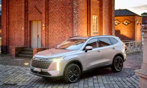 Srebrny Haval na brukowanej ulicy przed ceglanym budynkiem.