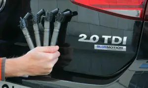 Dłoń trzyma cztery wtryskiwacze do silnika common rail 2.0 TDI.