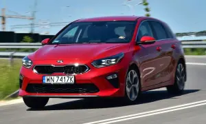 Czerwony Kia Ceed 1.4 benzyna w ruchu drogowym. Elegancki hatchback z dynamicznym wyglądem.