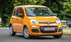 Pomarańczowy Fiat Panda 3 na drodze, z zielenią w tle.