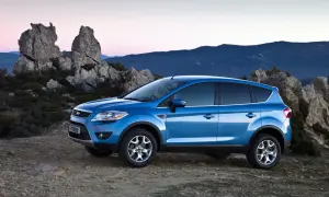 Niebieski Ford Kuga MK1 na tle skalistego krajobrazu o zachodzie słońca.