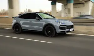 Szary Porsche Cayenne Turbo GT pędzi autostradą, zostawiając za sobą rozmyte tło.