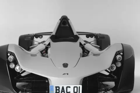 Biały, sportowy samochód BAC Mono z widocznym silnikiem i tablicą rejestracyjną "BAC 01".