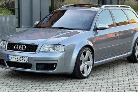 Srebrne Audi RS6 C5 Avant na kostce brukowej, z odbiciem zachodzącego słońca na karoserii.
