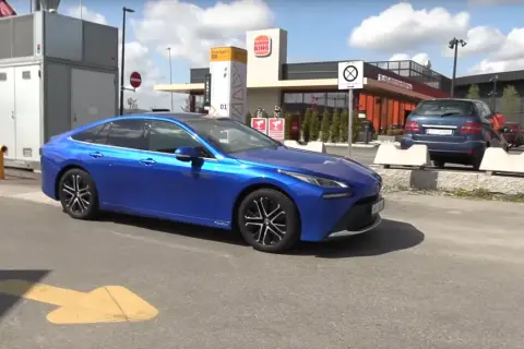 Niebieska Toyota Mirai, samochód wodorowy, parkuje obok stacji paliw. Sprawdzamy, jaka jest toyota mirai cena.
