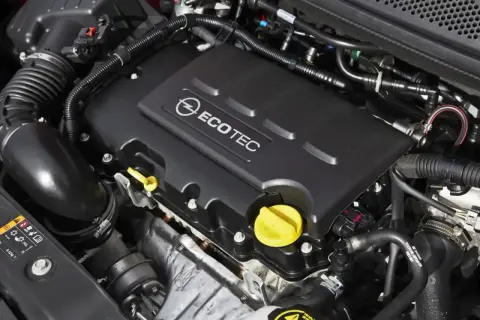 Silnik Ecotec w Oplu Astra J 1.4 Turbo. Widoczne elementy układu dolotowego i osłona silnika z logo.