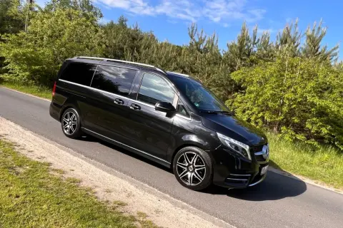 Czarny Mercedes-Benz V-klasa na drodze wśród zieleni.