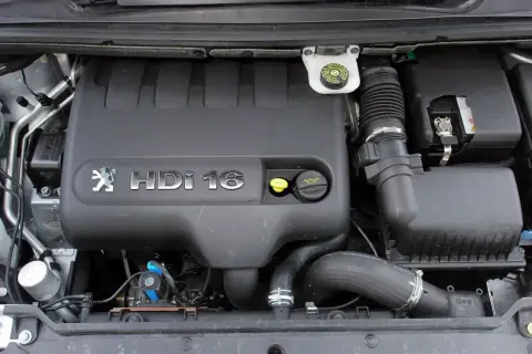 Silnik Peugeot 307 2.0 HDI 16V. Widoczny czarny plastikowy kolektor, przewody i akumulator.
