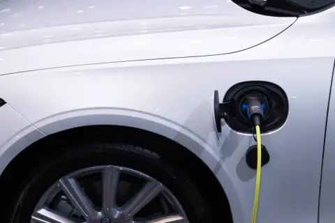 Ładowanie samochodu elektrycznego: wtyczka w gnieździe, pytanie brzmi, jak długo trwa ładowanie.