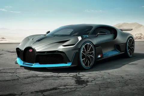 Szary Bugatti Divo z niebieskimi akcentami na pustynnej drodze.